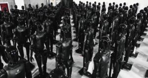 Rows of black AgiBot Expedition A2 humanoid robots standing on stands inside an AgiBot facility
