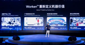 AgiBot co-founder Peng Zhihui on a stage in front of a large screen titled Worken Redefining Machine Value, showing four robot deployment panels with Worken scores
