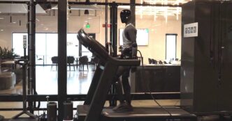 Figure 03 humanoid robot in a gray tank top walking on a treadmill in Figure's office, with a cable running from the robot