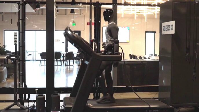 Figure 03 humanoid robot in a gray tank top walking on a treadmill in Figure's office, with a cable running from the robot