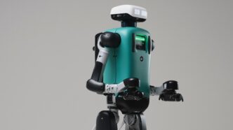 Agility Robotics Digit humanoid with a teal torso and white head unit, arms bent forward, against a grey studio backdrop