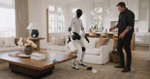 White Figure 03 humanoid robot carrying a fabric basket while tidying toys in a bright living room as a man in a dark shirt watches beside a sofa