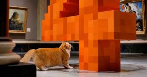 An orange cat walks through a marble art gallery toward a giant orange pixel-block sculpture of the number 4, a still from Mistral's Large 4 launch video