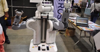 Willow Garage PR2 research robot, a white two-armed mobile robot with a camera-equipped head, shown at an exhibition