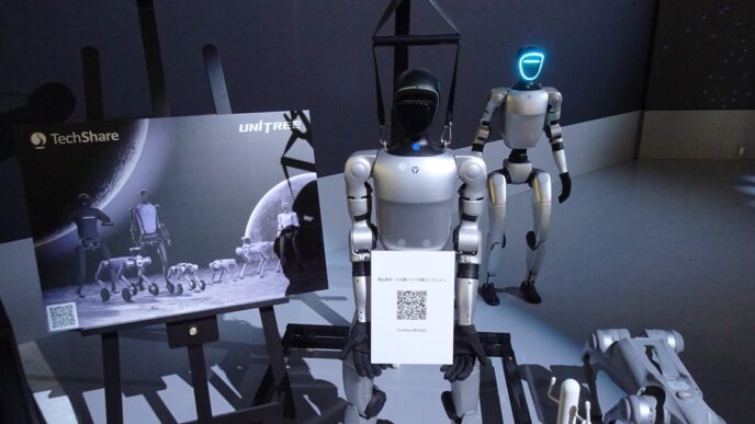 Unitree G1 and H1 humanoid robots and a Go2 quadruped on display at a TechShare booth at Japan Mobility Show 2025