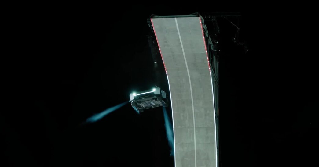 White Tesla Roadster in midair beside a curled concrete ramp at night, firing blue cold-gas thruster plumes during Tesla's October 15, 2026 reveal