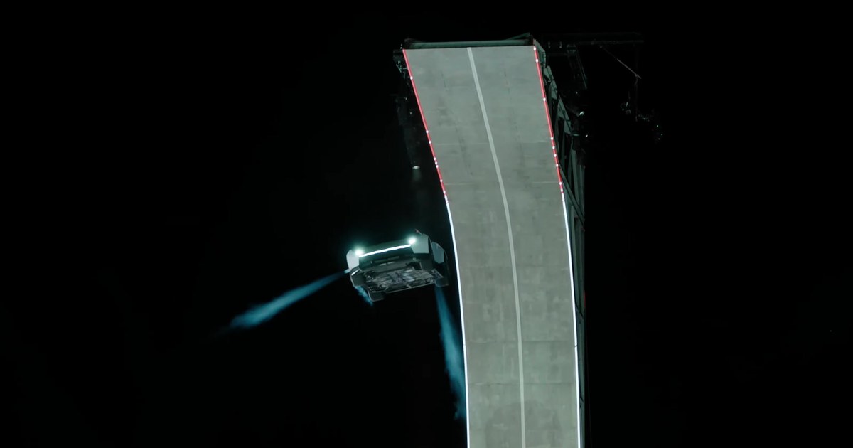 White Tesla Roadster in midair beside a curled concrete ramp at night, firing blue cold-gas thruster plumes during Tesla's October 15, 2026 reveal