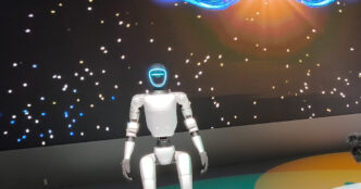 Unitree G1 humanoid robot standing on a lit circular stage at the Japan Mobility Show 2025