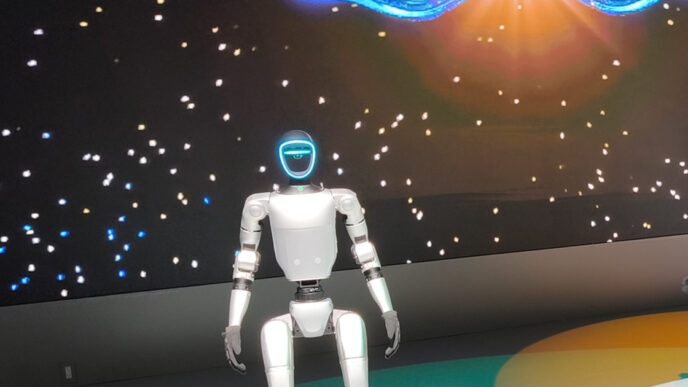Unitree G1 humanoid robot standing on a lit circular stage at the Japan Mobility Show 2025