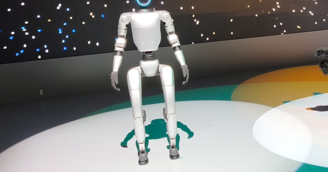 Unitree G1 humanoid robot standing on a lit circular stage at the Japan Mobility Show 2025