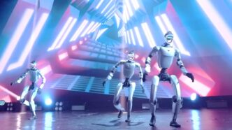 Three Unitree humanoid robots dancing on a stage with LED lighting in Unitree's UniUni swarm control launch video
