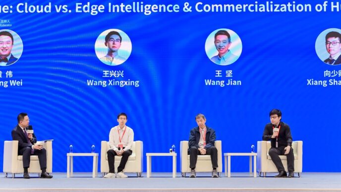 Four men in white armchairs on a stage at the 2026 China International Industry Fair, below a blue screen showing their photos and names: Huang Wei, Wang Xingxing, Wang Jian and Xiang Shaoqing